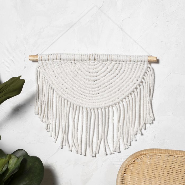 A macramé wall hanging braided in a semi circle