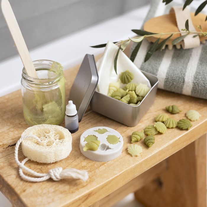 Travel container with small olive oil soaps and loofah sponge