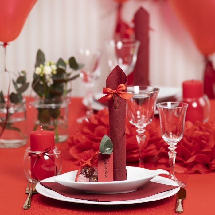 Red Table Decorations with Paper Flowers, Balloons, a Napkin folded like a Tower and Place Cards