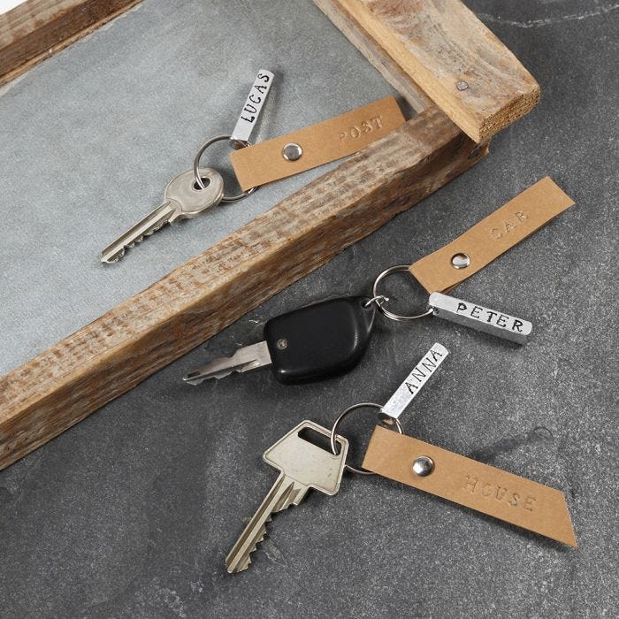 A Key Fob with an embossed Metal Name Tag and a Faux Leather Paper Tag