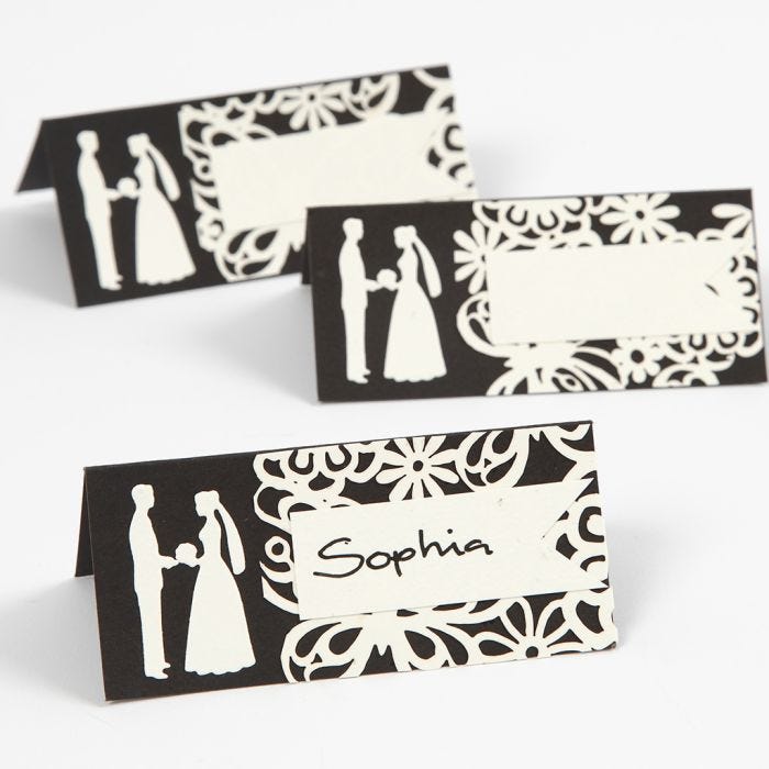 A place card with a punched-out wedding design and laced card