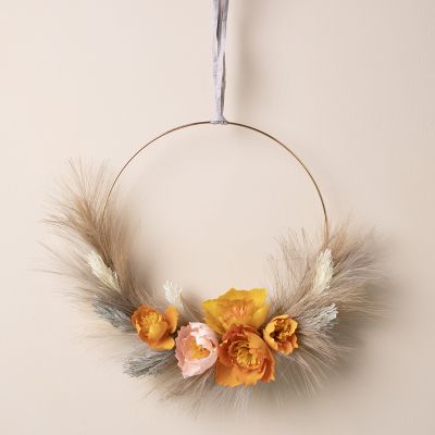 Une couronne d’automne avec des fleurs en papier crépon et de l’herbe de pampa