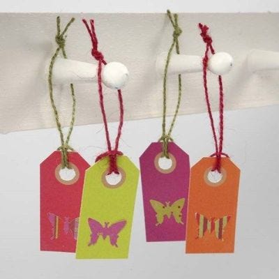 A Butterfly punched out from Design Paper on a Manilla Tag
