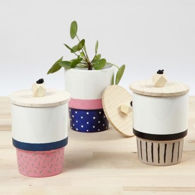 A Mug decorated with Porcelain Paint and a Lid with a wooden Bead