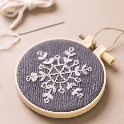 Embroidery frame with embroidered snowflake